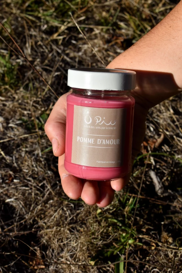 DSC_0290-pomme-damour main qui tient une bougie rose senteur Pomme d'amour de la marque Ôpic